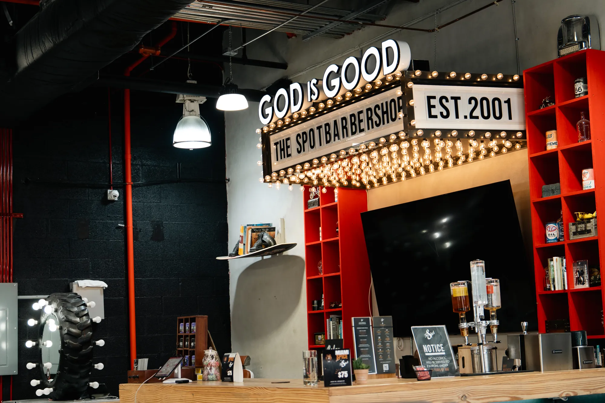 The GOD IS GOOD sign over the bar at The Spot Barbershop